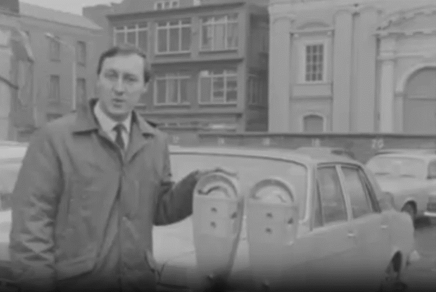 RTE reporter stands beside Duncan parking meters as he talks abou ttheir introduction to Dublin in 1969