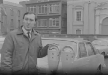 RTE reporter stands beside Duncan parking meters as he talks abou ttheir introduction to Dublin in 1969